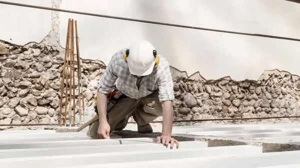 建筑工人在工作时戴着头盔 检查房屋二层地基底部的梁尺寸和距离 以及建筑工地的背景 — 图库照片