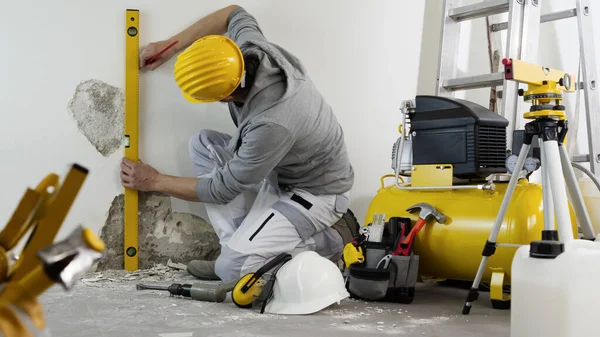 Hus Renovering Koncept Man Arbetare Tittar Spritnivån Kontrollerar Väggen Hjälm — Stockfoto