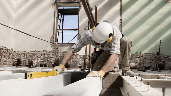 Mann Bei Der Arbeit Bauarbeiter Trägt Helm Und Benutzt Wasserwaage — Stockfoto