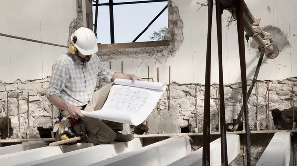 Człowiek Pracy Pracownik Budowlany Kasku Patrząc Plan Sprawdź Plan Projektu — Zdjęcie stockowe