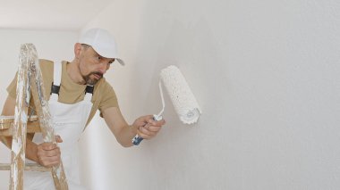 Boyacı adam dekoratörlüğü, yenileme işi, duvarda paten boyası, ahşap merdiven, beyaz üzerine izole edilmiş, arkaplan kopyası.