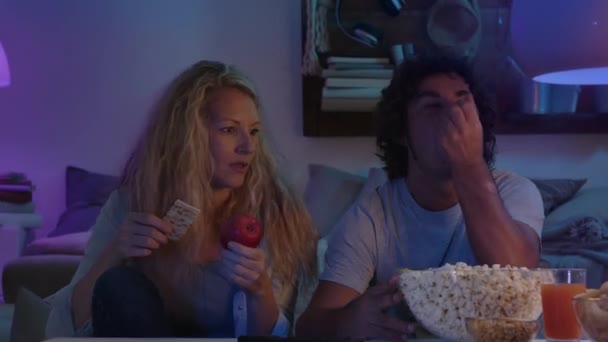 Pareja Viendo Televisión Noche Casa Ella Está Dieta Con Manzanas — Vídeo de stock