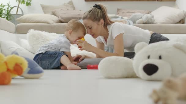 Lycklig Och Leende Mamma Gör Sin Vackra Baby Dricka Apelsinjuice — Stockvideo