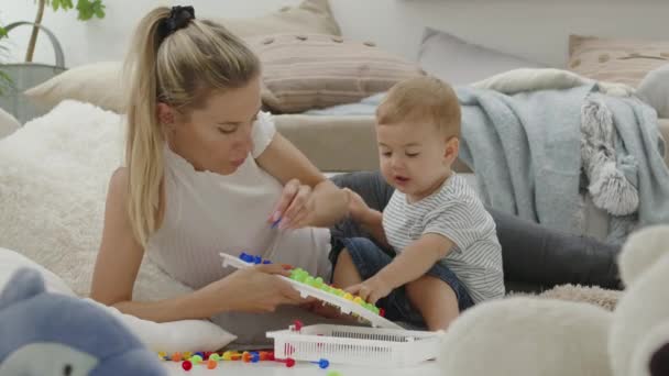 Feliz Mamá Sonriente Juega Con Hermoso Bebé Con Colorido Juguete — Vídeos de Stock