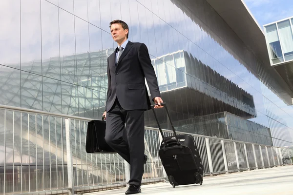 Uomo d'affari che cammina con carrello e borsa, viaggi d'affari — Foto Stock