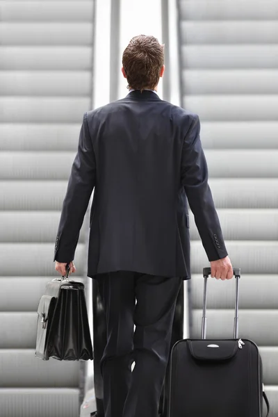 Uomo d'affari in scala mobile con borsa e carrello, viaggi d'affari — Foto Stock