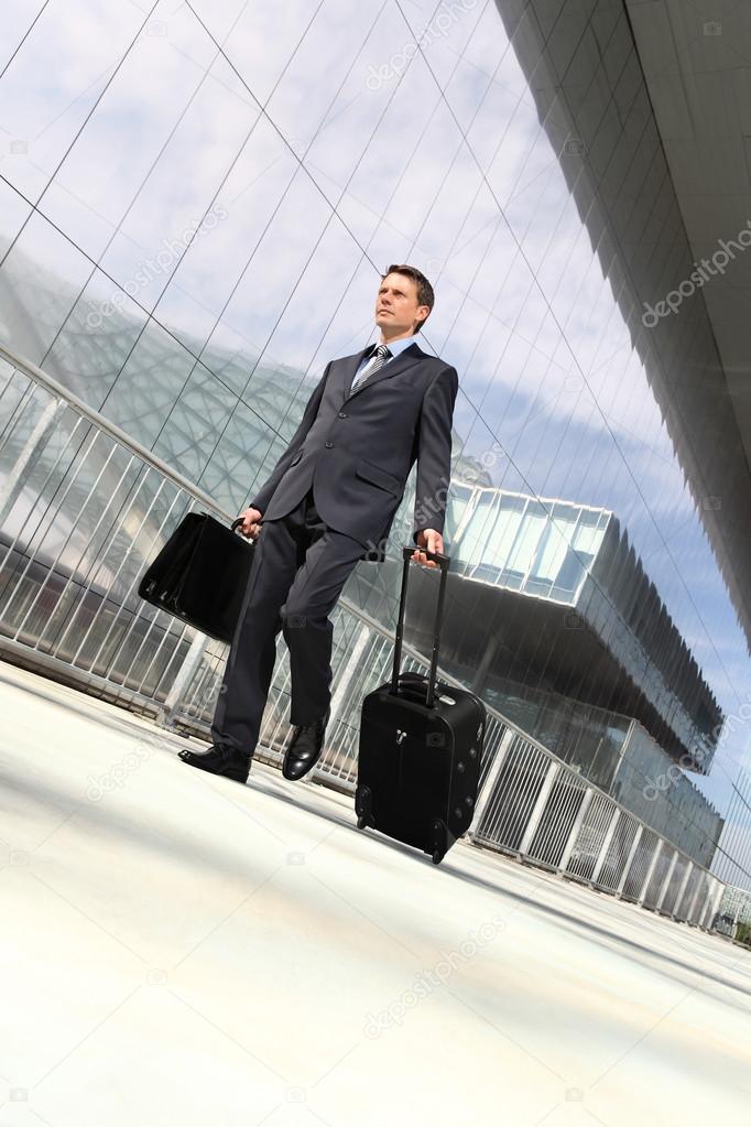 Businessman walking with suitcase and trolley