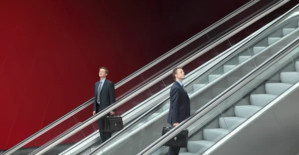 Hombre de negocios subiendo y bajando escaleras mecánicas, concepto de éxito — Foto de Stock