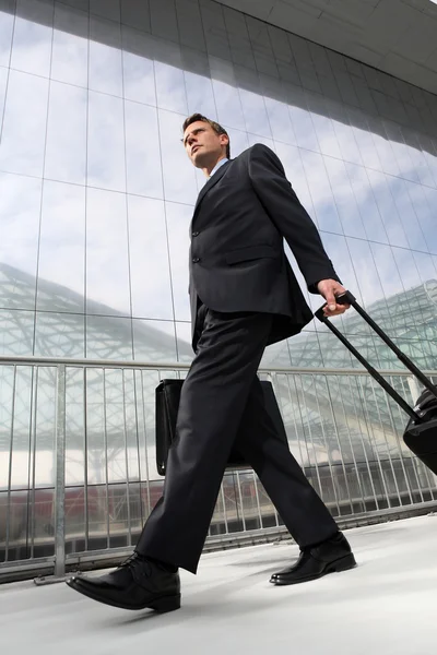Uomo d'affari che cammina con borsa e carrello — Foto Stock