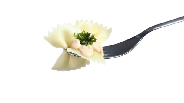 Forchetta di fiocco di pasta alle farfalle condita con salsa di rose e prezzemolo isolata su fondo bianco — Video Stock