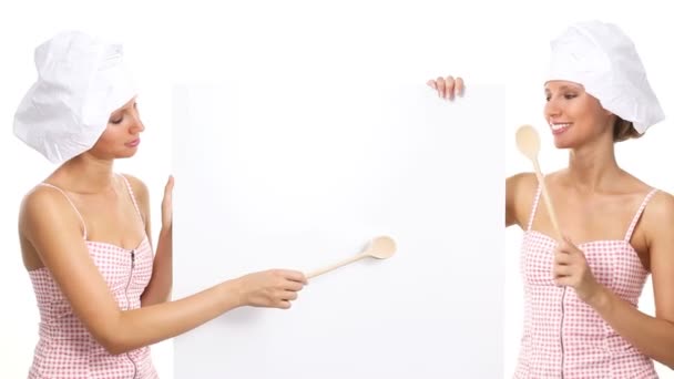 Chef mujer señalando con una cuchara de madera en la cartelera blanca — Vídeos de Stock