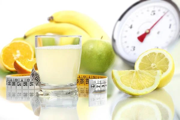 Лимонный сок наливают в стекло, фруктовые весы диетическая пища — стоковое фото