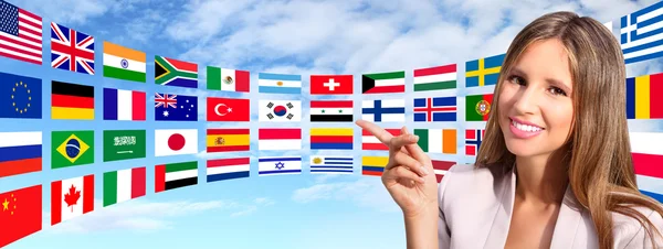 Mosolygó nő azt mutatja, hogy nemzetközi zászlók — Stock Fotó
