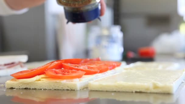 Handen bereiden een broodje kaas en tomaat — Stockvideo