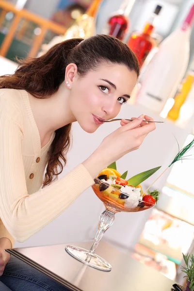 Lächelndes Mädchen im Kaffee, das ein Eis isst — Stockfoto