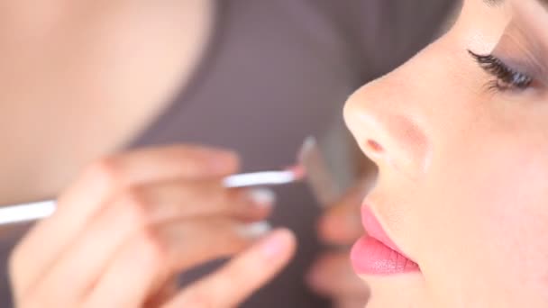 Makeupartist om läppstift på modell läppar med pensel - närbild — Stockvideo