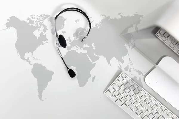 Contacto concepto global, mesa de vista superior con auriculares, ordenador y mapa — Foto de Stock