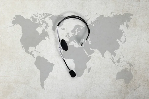 Contacto concepto global, auriculares de vista superior y mapa — Foto de Stock