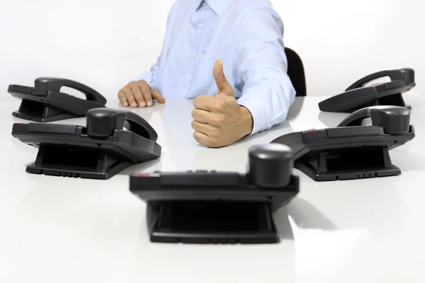 Como mano con teléfonos de oficina en el escritorio — Foto de Stock