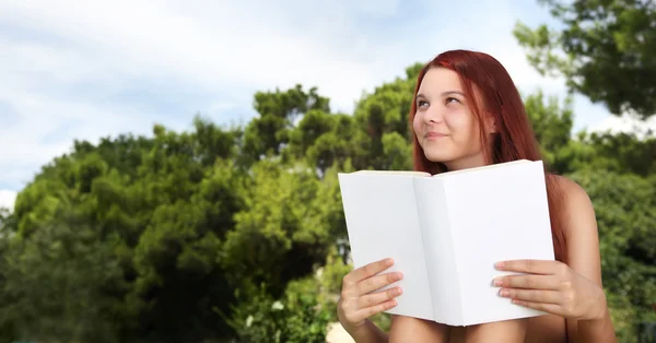 School meisje in het park met het boek — Stockfoto