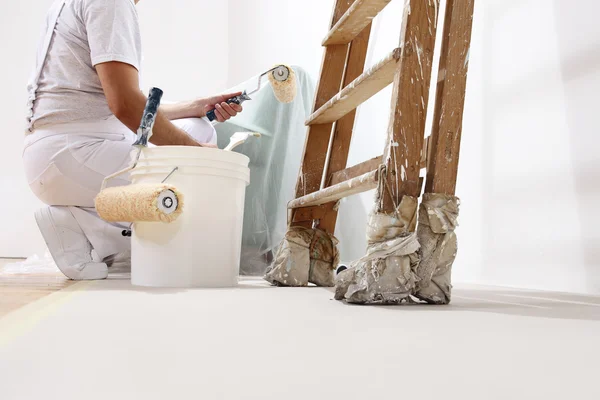 Painter man at work with a roller, bucket and scale, bottom view — Stock Photo, Image