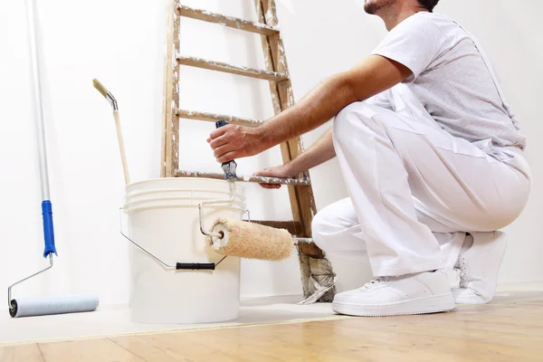 Schilder mens op het werk met een roller, emmer en schaal, onderste weergave Stockfoto