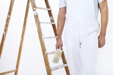 ressam adam bir boya fırçası ve merdiven ile iş yerinde
