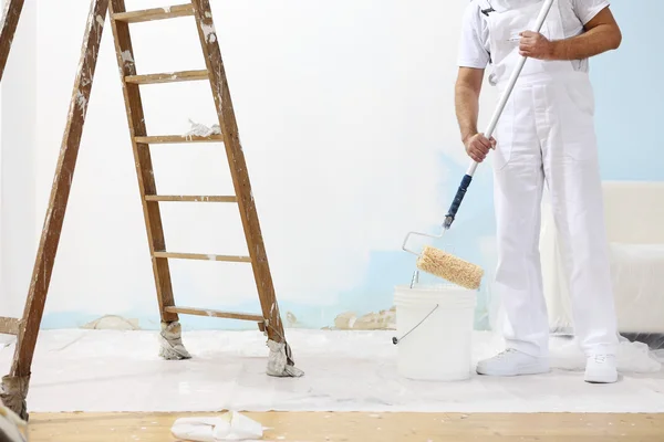 Painter man at work takes the color with paint roller from bucket — Stock Image Painter man at work takes the color with paint roller from bucket Royalty Free Stock Images
