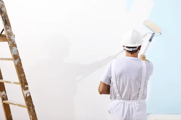 Painter man at work with a paint roller on the wall — Stock Image Painter man at work with a paint roller on the wall Stock Photo