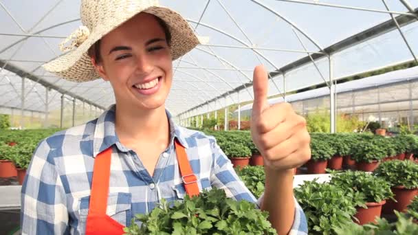 Donna sorridente in serra con mano simile — Video Stock