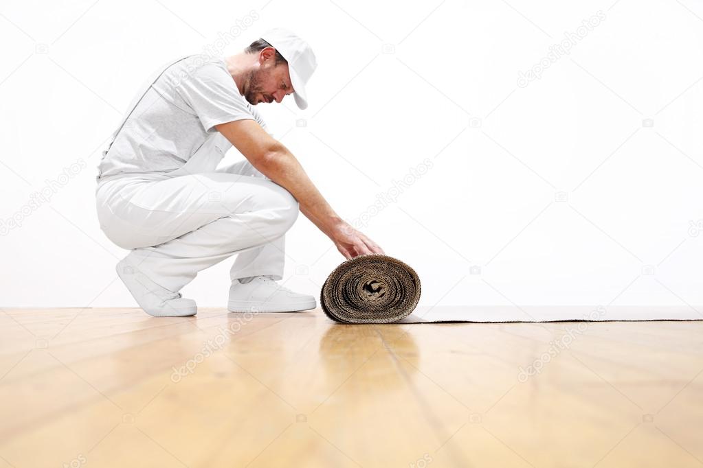 painter man at work, rolls the cardboard on the floor