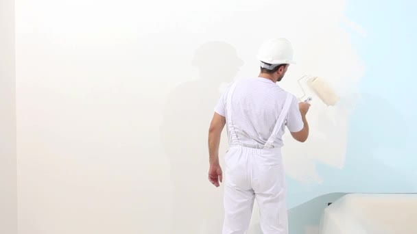 ローラー塗装壁、画家の家のコンセプトで、職場で画家の男 — ストック動画