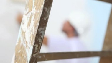 ressam adama yakın çekim silindir boyama duvar ile çalışmak ve Ahşap merdiven