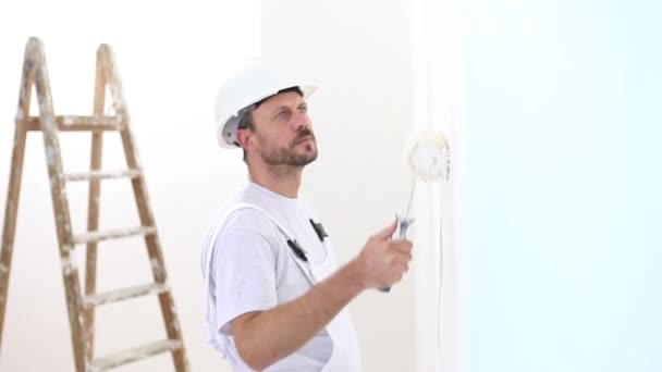 Malermann bei der Arbeit, mit Rollenmalwand, Malerhauskonzept — Stockvideo