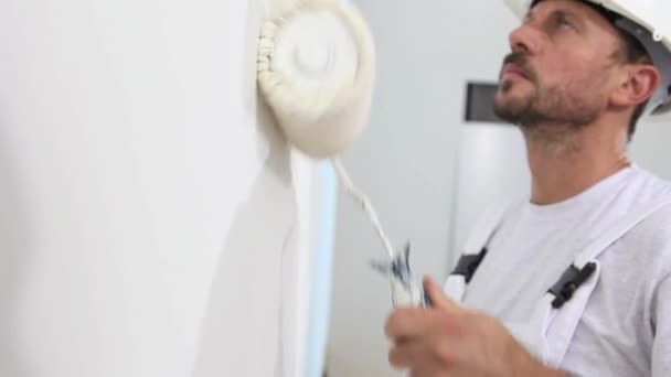 Pintor hombre en el trabajo, con la pared de pintura del rodillo, concepto de la casa del pintor — Vídeos de Stock