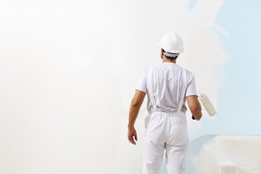 painter man at work with a paint roller, wall painting concept clipart