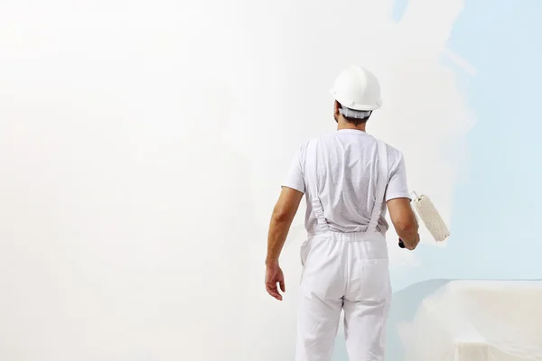 Pittore uomo al lavoro con un rullo di vernice, pittura murale concetto Fotografia Stock