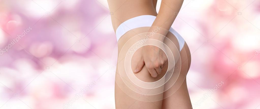 Woman pinches her thigh to control cellulite