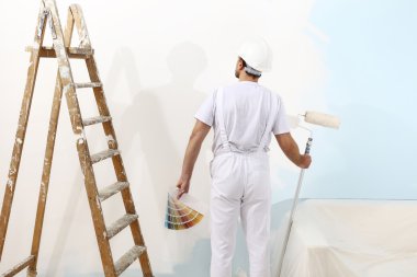 ressam adam bir rulo ve renk örnekleri, duvar ile iş yerinde