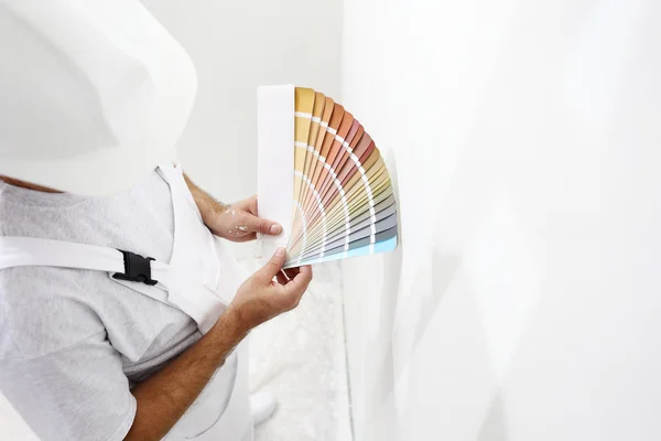 Pintor hombre con muestras de color en la mano —  Fotos de Stock