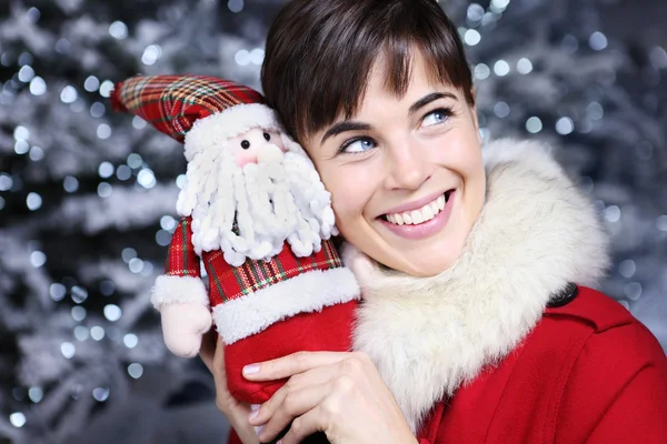Christmas kvinnan leende med gåva, Santa Claus leksak, — Stockfoto