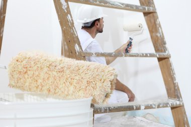 ressam adam bir boya silindiri, duvar boyama kavramı ile iş yerinde