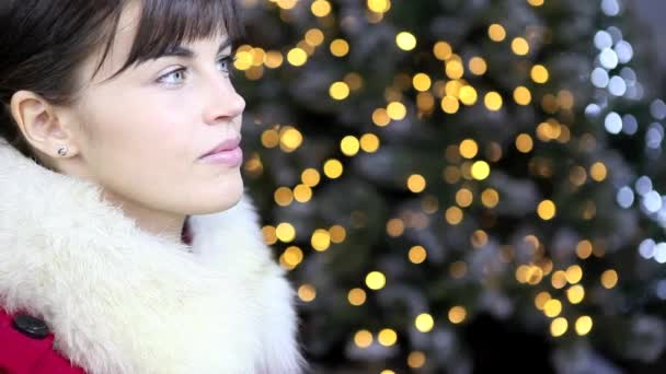 Weihnachtsfrau mit goldener Kugel, lächelnd auf Lichterhintergrund — Stockvideo