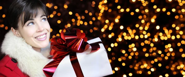 Vánoční žena s dárkové balení prezentovat, usmíval se a dívá se nahoru — Stock fotografie