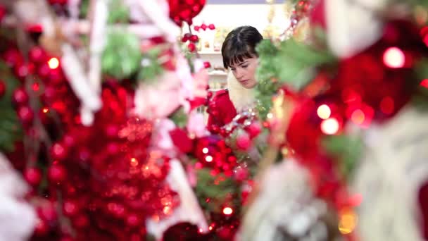 Frau kauft Weihnachtsschmuck für Baum im Marktladen — Stockvideo