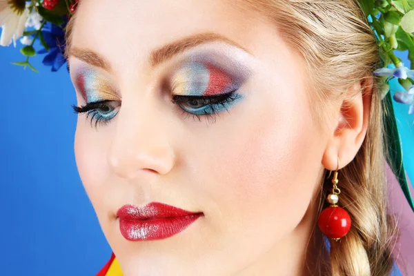 Retrato mujer maquillaje con flores sobre fondo azul, concepto de primavera —  Fotos de Stock