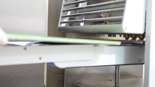 Промышленный кондитер готовит слойки с помощью порционирующей машины — стоковое видео