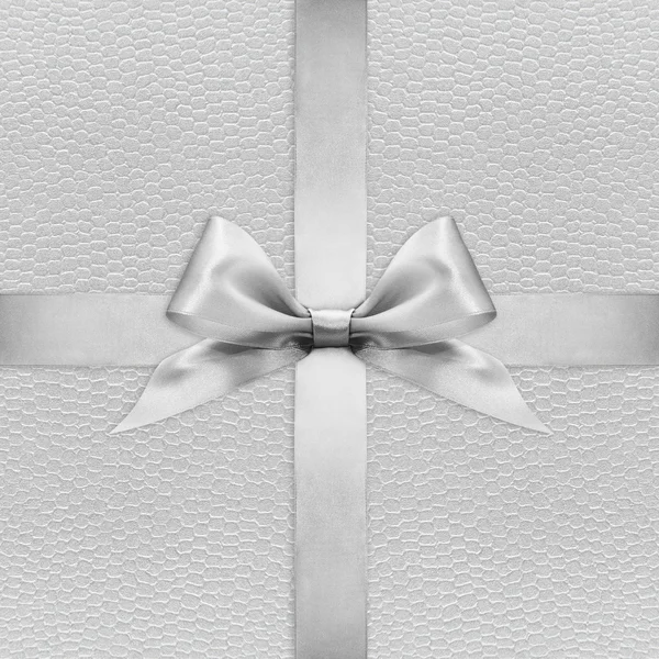 銀色の背景に光沢のあるシルバー サテン リボン弓 — ストック写真