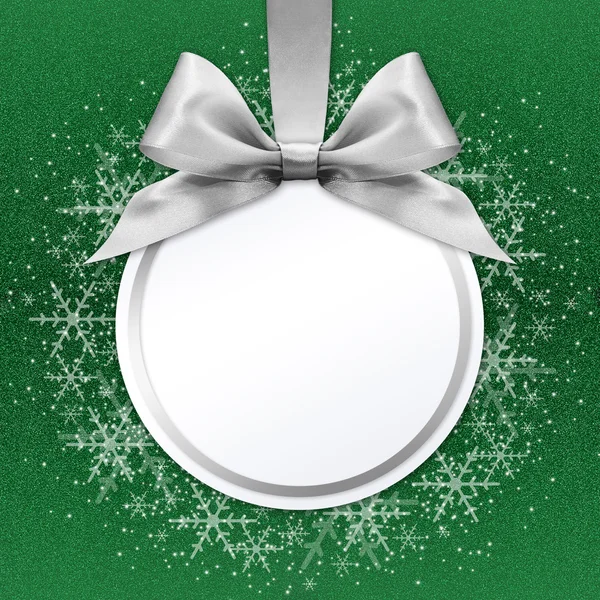Bola de Natal com arco de fita de cetim prata no fundo verde — Fotografia de Stock