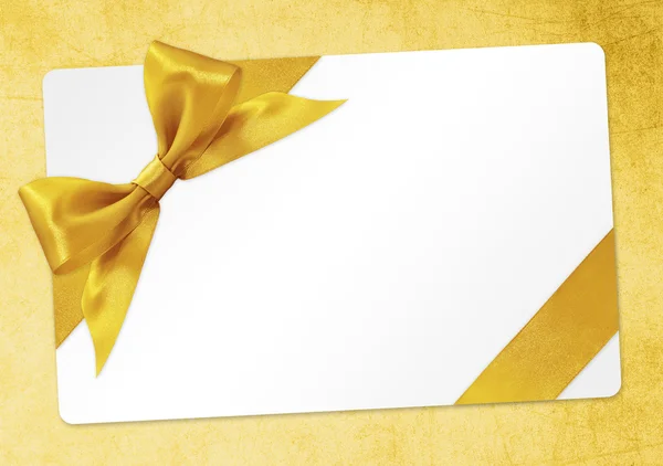 Gift card with golden ribbon bow Isolated on yellow background — Stock Photo, Image